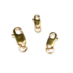 May include: Three gold-toned lobster clasps, a common jewelry finding used for necklaces, bracelets, and other jewelry pieces.