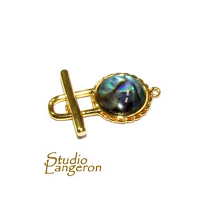 Op de afbeelding: Gouden toggle-sluiting met een ronde inleg van abalone-schelp. De sluiting is perfect voor kettingen, armbanden of andere sieradenprojecten.