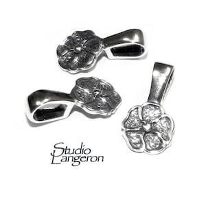 May include: Three silver flower-shaped pendant bails. Each bail has a loop at the top and a flower design at the bottom.
