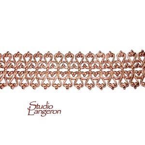 Puede incluir: Una moldura de metal de color cobre con un diseño delicado e intrincado que presenta patrones repetidos en forma de corazón. La moldura es ideal para agregar un toque decorativo a las manualidades y los proyectos.