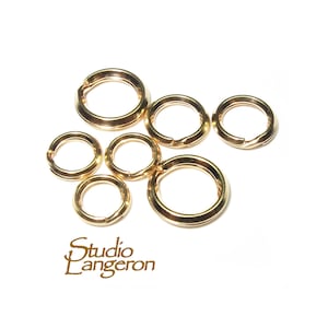 Op de afbeelding: Een set van zes gouden springringen in verschillende maten. De ringen zijn glad en hebben een gepolijste afwerking.