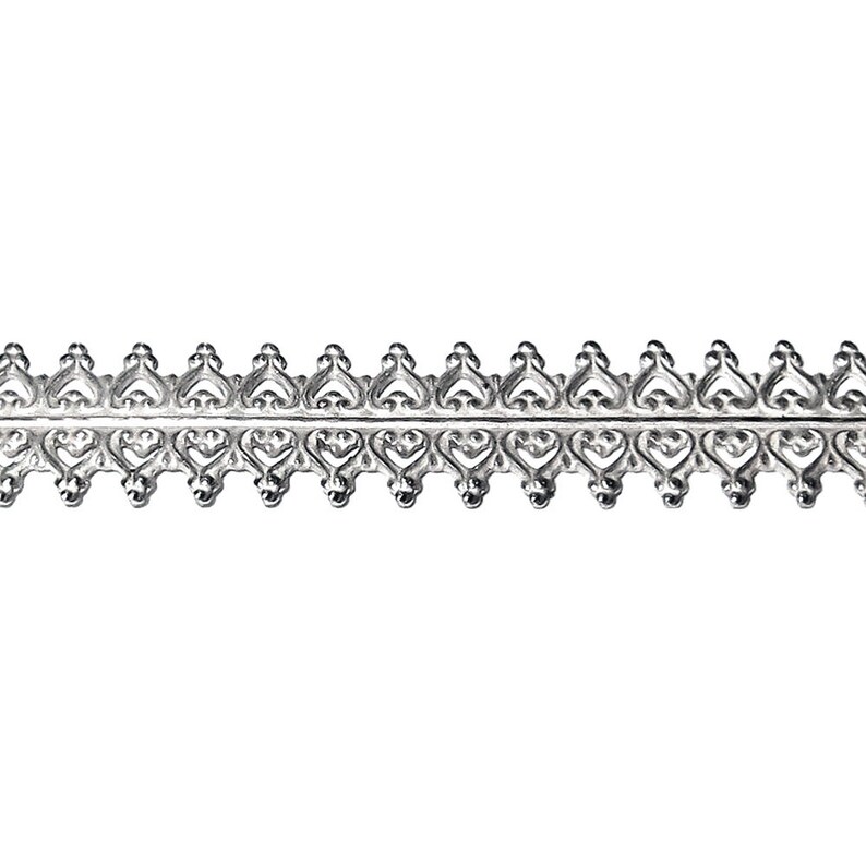 Peut inclure: Garniture en m&eacute;tal argent&eacute; avec un motif de c&oelig;ur r&eacute;p&eacute;t&eacute;. La garniture a un motif d&eacute;licat et complexe.