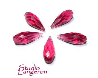 May include: Five faceted teardrop shaped beads in a bright pink colour. The beads are arranged in a starburst pattern on a white background.