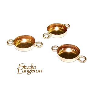 May include: Three gold-toned metal bezel settings with two loops on each side. The bezels are round and have a smooth, shiny finish.
