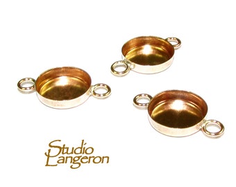 May include: Three gold-toned metal bezel settings with two loops on each side. The bezels are round and have a smooth, shiny finish.