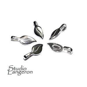 May include: Five silver leaf-shaped pendant clasps, each with a small loop at the top. The clasps are arranged in a star shape. One clasp has the marking "NIC 925" on the back.