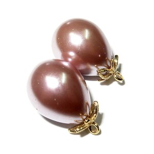 May include: Two pearlescent pink teardrop-shaped beads with gold-tone bow accents. The beads are approximately 1 inch in length.