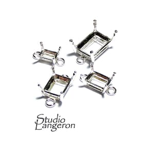 May include: Four silver-toned metal bezel settings with jump rings. The bezels are rectangular and have a smooth finish. They are designed to hold gemstones or other decorative elements.