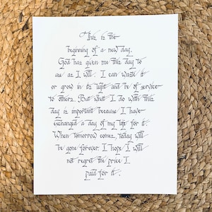 May include: A handwritten quote on a white piece of paper with black ink. The quote reads: "This is the beginning of a new day. God has given me this day to use as I will. I can waste it or grow in its light and be of service to others. But what I do with this day is important because I have exchanged a day of my life for it. When tomorrow comes, today will be gone forever. I hope I will not regret the price I paid for it."