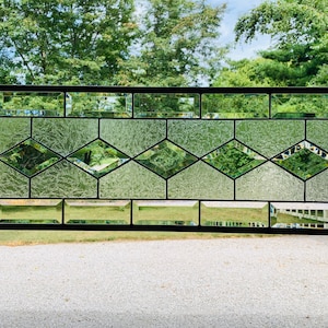 May include: A stained glass window with a diamond pattern. The glass is clear and has a textured surface. The window is framed in black metal.