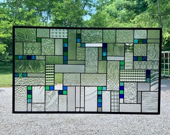 May include: A stained glass window with a geometric design featuring various shades of green and blue glass.