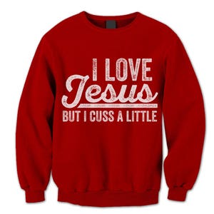 May include: Red sweatshirt with a white distressed graphic that says "I love Jesus but I cuss a little."