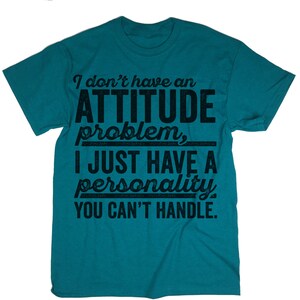 May include: Teal blue t-shirt with a distressed black graphic that reads "I don't have an ATTITUDE problem, I JUST HAVE A personality YOU CAN'T HANDLE."