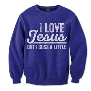 May include: A royal blue long-sleeved sweatshirt with a white distressed graphic that reads "I love Jesus but I cuss a little."