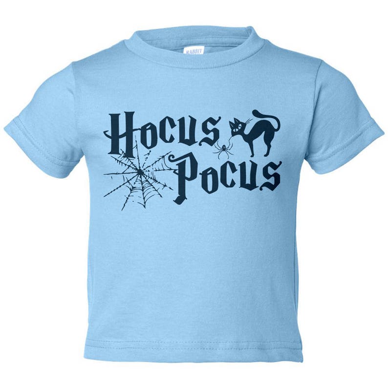 K&ouml;nnte beinhalten: Hellblaues T-Shirt mit einer schwarzen Grafik einer Spinne, einer schwarzen Katze und dem Text "Hocus Pocus".