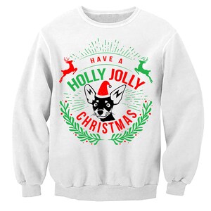 May include: White sweatshirt with a green and red Christmas design featuring a black and white dog wearing a Santa hat. The text reads "Have a Holly Jolly Christmas".