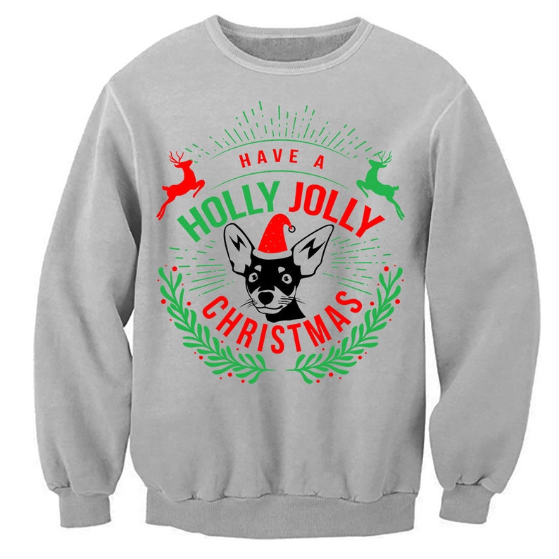 May include: A grey sweatshirt with a Christmas design featuring a black and white dog wearing a red Santa hat. The text on the sweatshirt reads "Have a Holly Jolly Christmas".