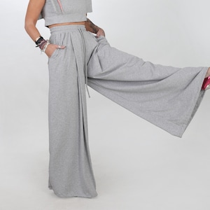 Könnte beinhalten: Graue weite Hose mit hoher Taille und Kordelzug. Die Hose ist aus einem weichen, bequemen Stoff.
