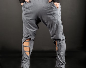 May include: Gray sweatpants with cutouts on the legs. The sweatpants have a low rise and a relaxed fit.