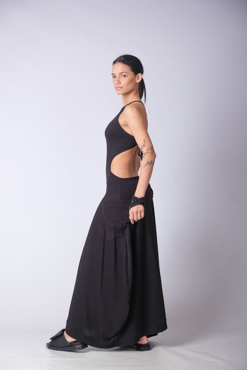 May include: A black maxi dress with a cutout back and a halter neckline. The dress is made of a soft, flowing fabric and has a relaxed fit.