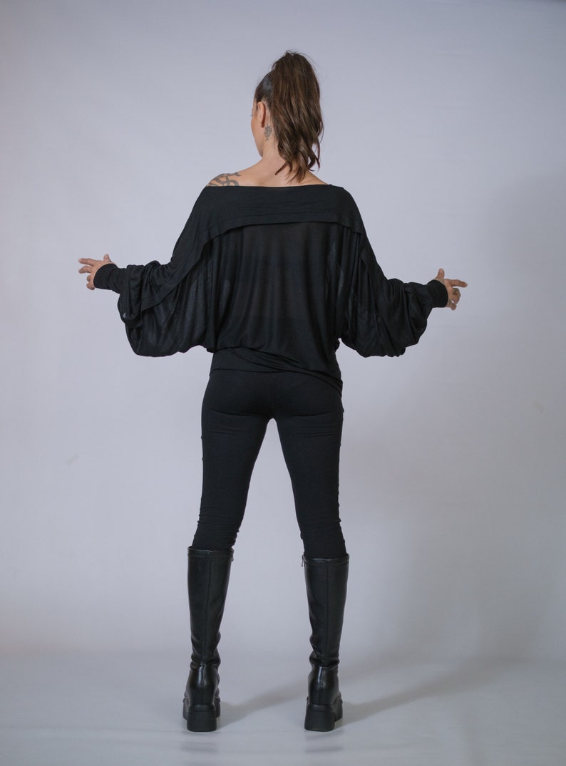 Oversized off-shoulder blouse with batwing sleeves, handmade alternative fashion.

Women’s loose draped tunic top, minimalist avant-garde streetwear.