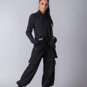 Women’s black baggy cargo pants made of soft heavy cotton with elastic waist and techwear style