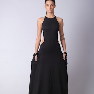 May include: A black maxi dress with a halter neckline and cutouts on the sides. The dress is made of a soft, stretchy fabric and has a flowing silhouette.