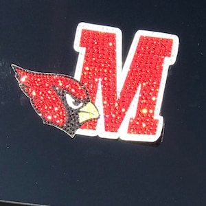 May include: A red and white rhinestone M with a red cardinal bird design.