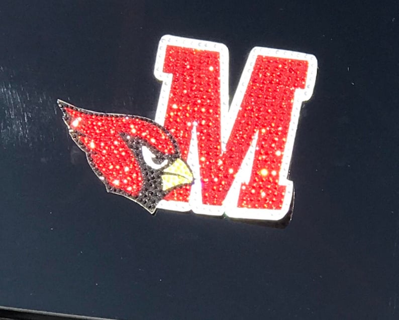 May include: A red and white rhinestone M with a red cardinal bird design.