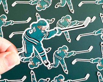 May include: A collection of hockey player stickers in teal and white, featuring a player in action with a hockey stick. The stickers have a dark teal background. The player's jersey has the name "SMITH" and the number "5".