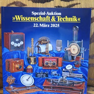 May include: A blue and yellow book cover with the title "Spezial-Auktion >>Wissenschaft & Technik<< 22. März 2025". The cover features a variety of antique scientific and technical instruments, including a camera, a microscope, a telescope, and a compass.