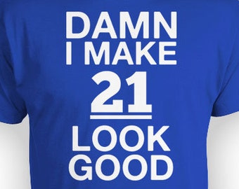Op de afbeelding: Koninklijk blauw T-shirt met witte tekst die "DAMN I MAKE 21 LOOK GOOD" zegt.