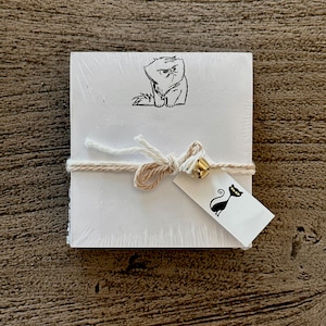 May include: A stack of white note cards with a black and white illustration of a cat on the top card. The cards are tied together with twine and a small tag with a black cat illustration.