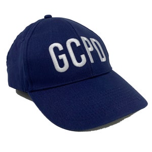 May include: A navy blue baseball cap with white embroidered lettering that reads "GCPD".