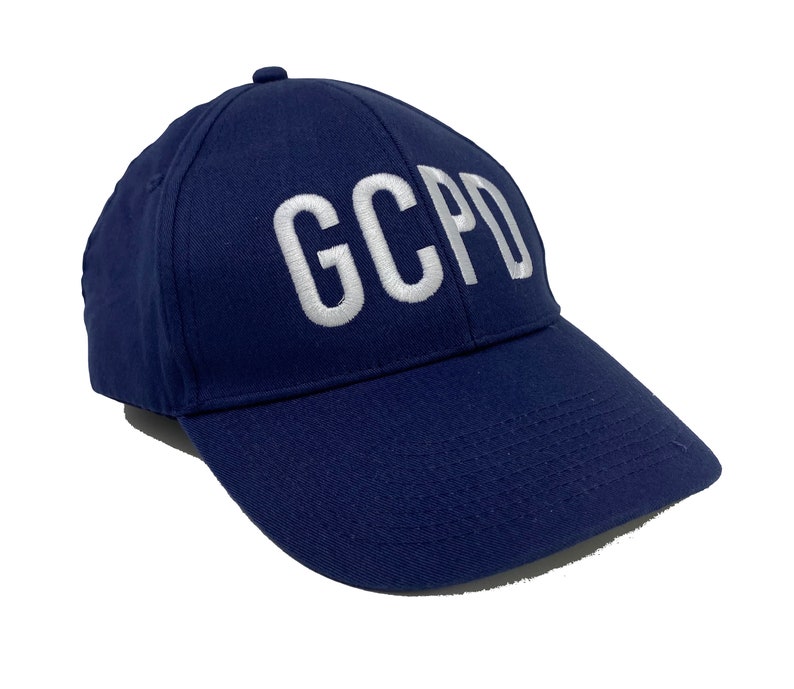 May include: A navy blue baseball cap with white embroidered lettering that reads "GCPD".