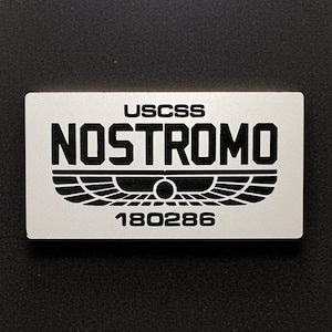 Insegna con logo USCSS Nostromo Alien Weyland Yutani. Realizzata in acrilico: disponibile con magnete o adesivo.