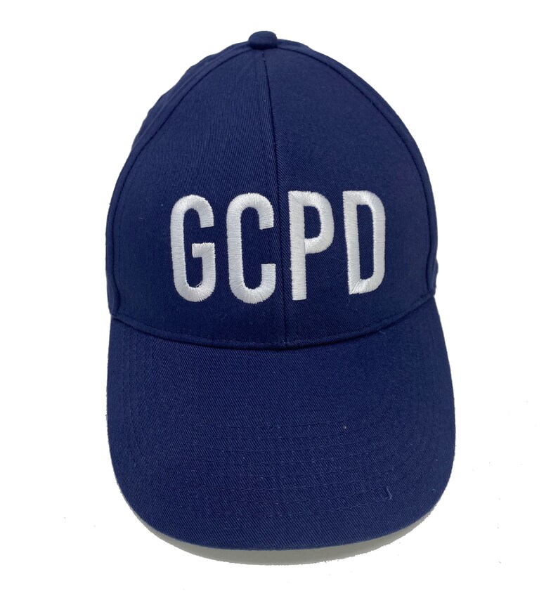 May include: A navy blue baseball cap with white embroidered lettering that reads "GCPD".