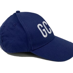 May include: A navy blue baseball cap with a white embroidered "GC" on the front.