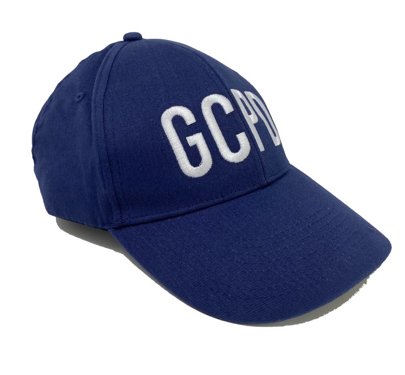 May include: A navy blue baseball cap with white embroidered text that reads "GCPD".