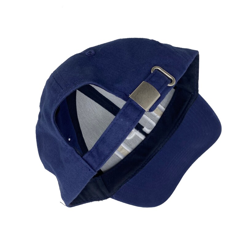May include: A navy blue baseball cap with a silver metal buckle closure. The cap is turned inside out, showing the white stitching on the inside.