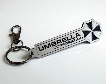 Sleutelhanger met logo van Raccoon City Umbrella Corporation. Gemaakt van acryl. Compatibel met Britse winkelwagenmunten