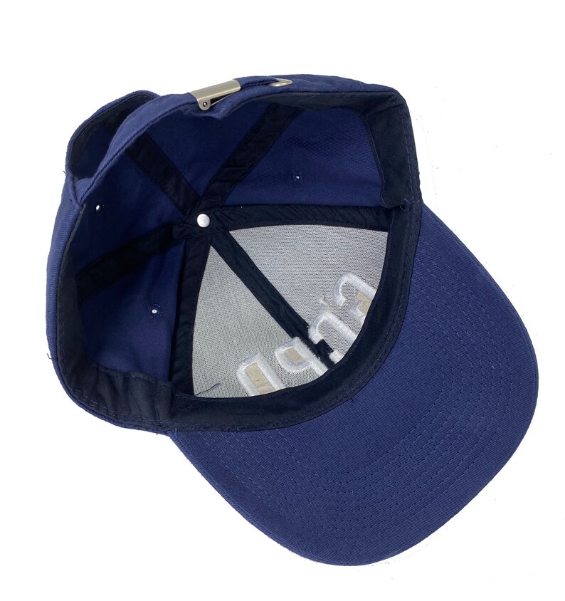 May include: A navy blue baseball cap with a white embroidered logo that says "C.U.P.P."