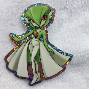 May include: A holographic sticker featuring a green and white anime character with a long, flowing dress. The character has large, green eyes and a pointed, green head.