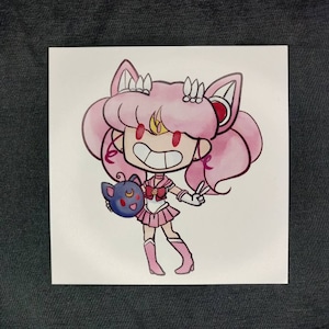 Könnte beinhalten: Eine rosa und weiße Comicfigur mit Katzenohren und einem roten Stern auf der Stirn. Sie hält eine blaue und schwarze Katze mit einem Halbmond auf der Brust. Die Figur trägt ein rosa und weißes Kleid mit einem gelben Stern.