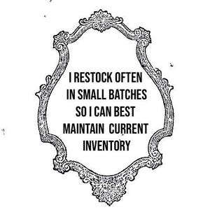 Pu&ograve; includere: Cartello con cornice ornata in bianco e nero con il testo: "I RESTOCK OFTEN IN SMALL BATCHES SO I CAN BEST MAINTAIN CURRENT INVENTORY". La cornice ha uno stile decorativo e vintage.