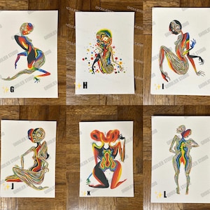 May include: Six colorful abstract art prints featuring a human figure with a rainbow color scheme. The prints are on white paper with a white border.