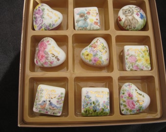 Puede incluir: Una caja con nueve cajas de recuerdo de porcelana, cada una con diseños florales y de animales. Las inscripciones en las cajas incluyen "Tooth Fairy Box", "Tooth Fairy Girl" y "Tooth Fairy Boy".