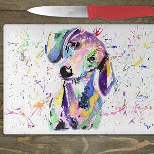 May include: A colorful watercolor painting of a dachshund dog with a white background. The dog is painted in shades of pink, purple, blue, green, and yellow. The background is covered in small, colorful paint splatters.