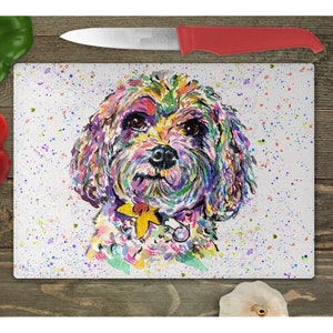 May include: A colorful watercolor painting of a small dog with a yellow flower on its collar. The dog is surrounded by white and colorful paint splatters on a white background.