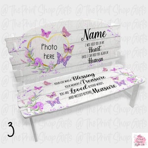 May include: White wooden memorial bench with a heart-shaped photo frame, purple flowers, and butterflies. The bench has the text "Name", "I will hold you in my heart until I can hold you again in heaven", "Your life was a blessing, your memory a treasure, you are loved beyond words and missed beyond measure".
